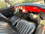 une voiture rouge et noire, avec des sièges et un tableau de bord en cuir noir