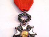 l'image d'une médaille ornée d'un ruban rouge sur un fond blanc