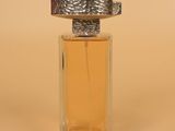 a close up of a bottle of perfume on a beige surface