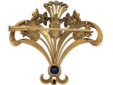 an image of a gold brooch with a blue stone in the center