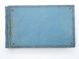 an old blue book sitting on top of a table next to a white wall