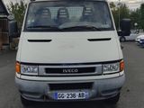 une camionnette blanche garée dans un parking avec d'autres voitures