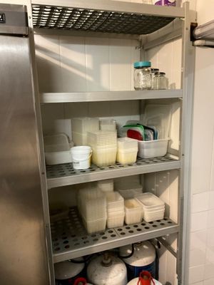 many containers of milk on the shelves in the kitchen