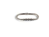 gros plan d'un bracelet en argent sur fond blanc