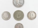 six different types of coins are shown on a white surface