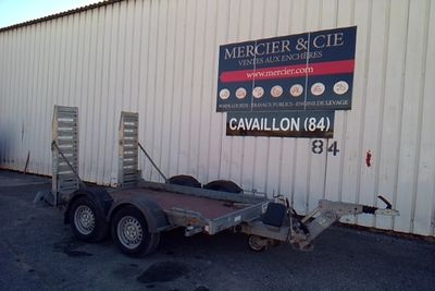 a trailer parked in front of a building with a sign on it