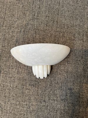 Applique en albâtre en forme de demi-coquille.