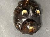 an image of a metal object with a face on it