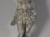 silver statue of a woman holding a flower in her right hand