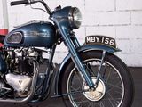 a blue motorcycle parked in front of a white brick wall
