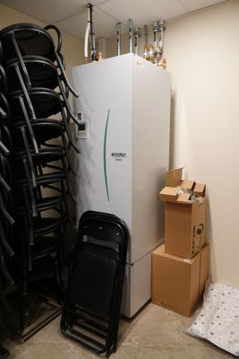 de nombreuses chaises et un réfrigérateur dans une pièce remplie de cartons
