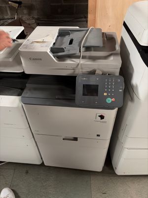 un homme qui se tient à côté d'une imprimante
