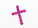 a cross made out of pink stones on a white surface
