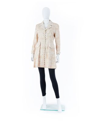 un mannequin blanc vêtu d'un manteau beige et d'un legging noir