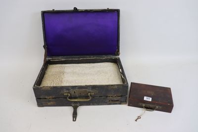 an old suitcase with a purple cover and a small wooden box
