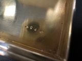 a silver box that has a small metal object inside of it