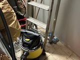 un aspirateur posé par terre à côté d'une échelle