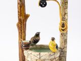une figurine représentant un puits sur lequel sont perchés des oiseaux