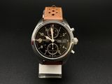 une image représentant une montre avec un bracelet en cuir marron sur un fond noir