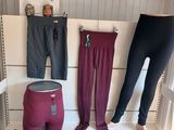 Plusieurs paires de leggings pour femmes sont exposées sur un banc blanc