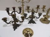 many different types of brass candlesticks on a table