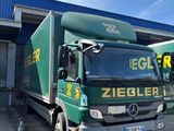 two trucks parked in front of a building in a parking lot