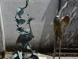 a statue of a bird sitting on top of a base next to a statue of a bird