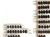 a wall of wine bottles on the shelves in the room