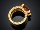 a yellow gold ring with a brown diamond and a white diamond