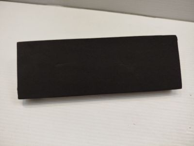 un morceau de papier noir sur une surface blanche