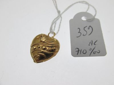 un pendentif en forme de cœur en or auquel est attachée une étiquette de prix