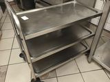 une cuisine avec une cuisinière et un chariot au milieu de la pièce