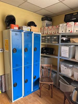 un casier bleu au milieu d'une pièce remplie de cartons