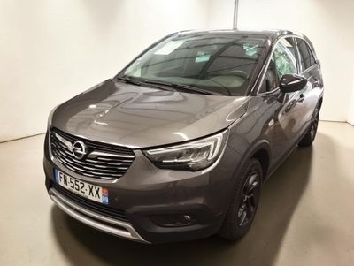Une Opel grise est garée dans une pièce blanche