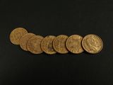 a close up of a pile of gold coins on a black surface