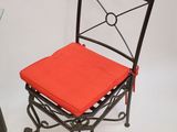 a chair with a red seat and a glass table