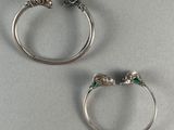 deux bagues en argent ornées de pierres vertes, posées sur une table