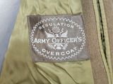 an army officer ' s overcoat with a military emblem on it