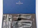 a blue box with silverware in it on a white surface