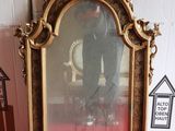 a picture of a gold framed mirror sitting on a red carpet