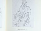 un livre ouvert sur lequel figure le dessin d'un homme assis sur une chaise