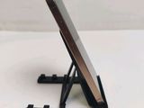 a cell phone sitting on a stand on a white surface