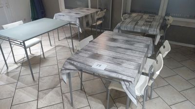tables and chairs in a room with tile flooring and a window