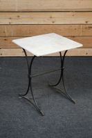 Petite table de type bistrot reposant sur un piétement en fe…