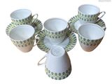 several cups and saucers are arranged in a circle on a white surface
