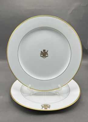 a white plate with gold trim and a gold emblem on it