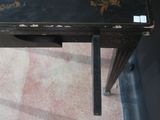 a small black table with a floral design on it