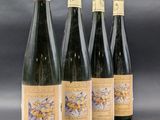 six bottles of wine are lined up on a gray surface