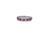 a close up of a ring with pink stones on a white background