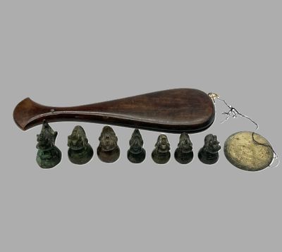 une cuillère en bois avec un manche en bois, posée à côté d'un groupe de petites figurines